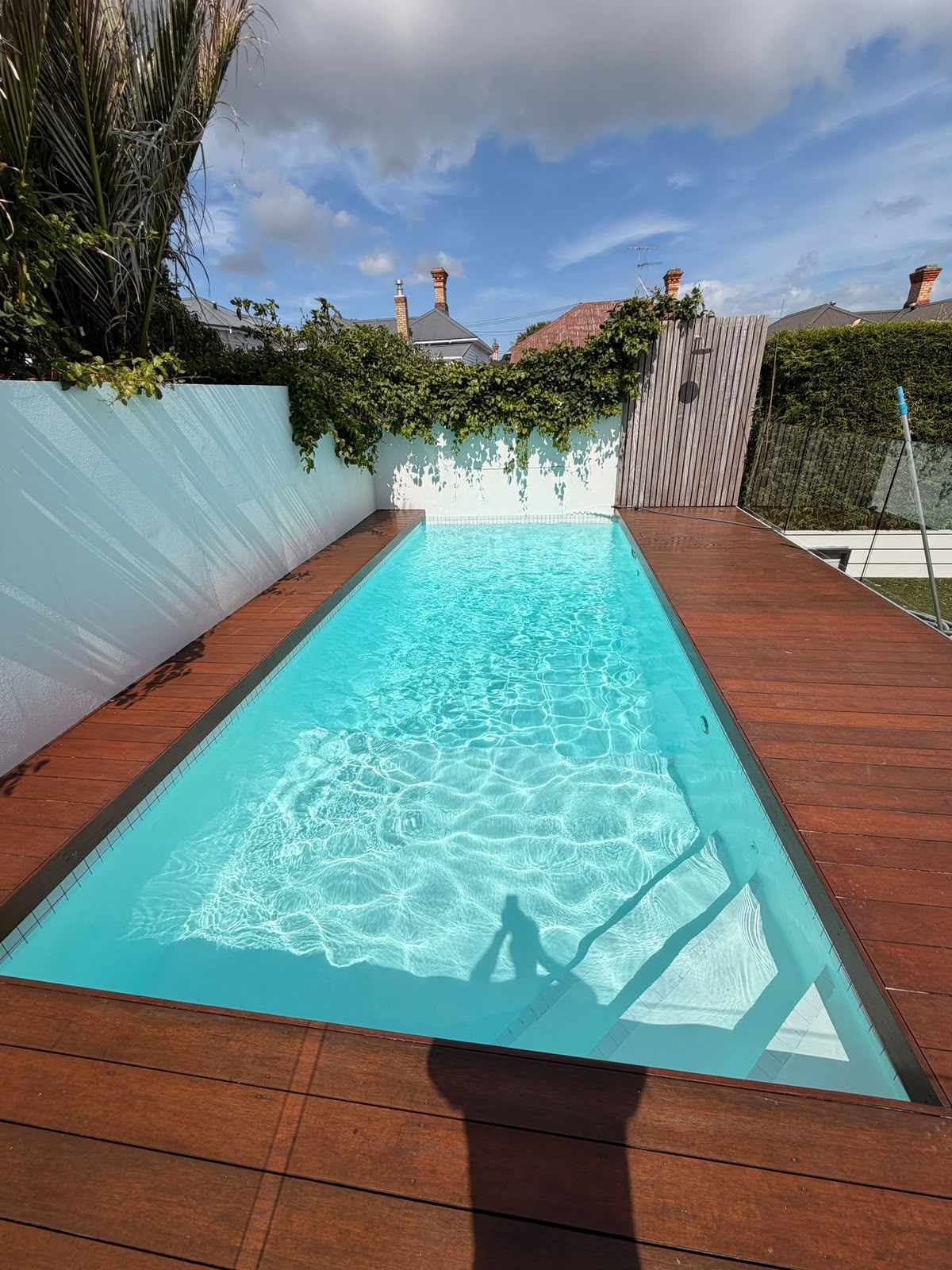 Refilled pool with clear aqua water and timber deck surround